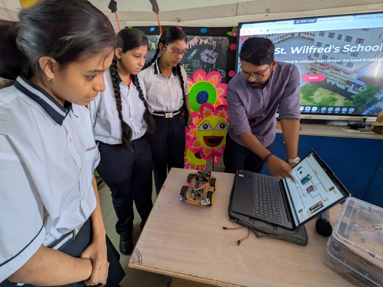 Teacher training students on Arduino robotics at a partner school